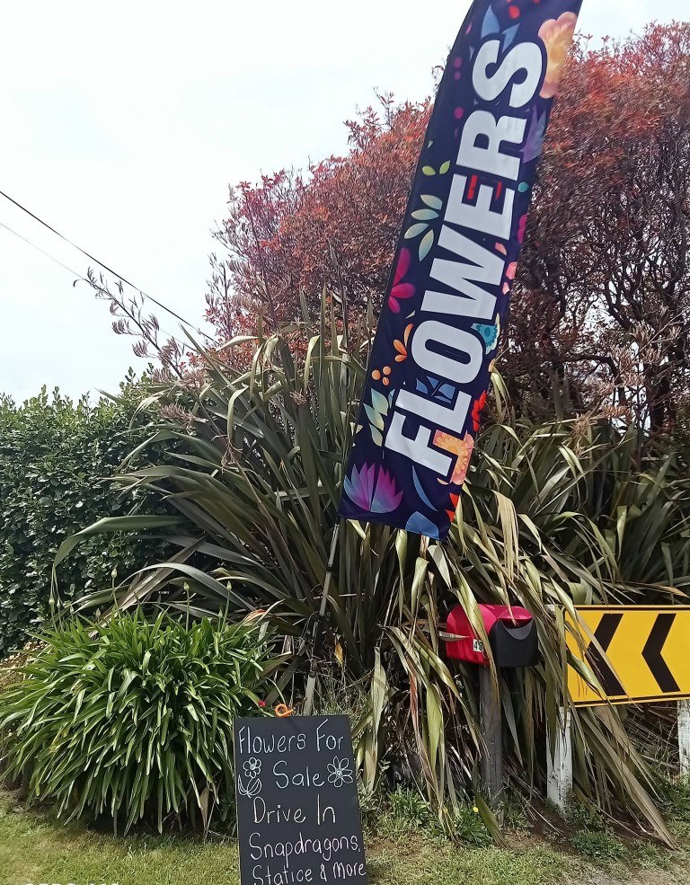 The FLOWERS flag and chalkboard at the No. 2 Road gate